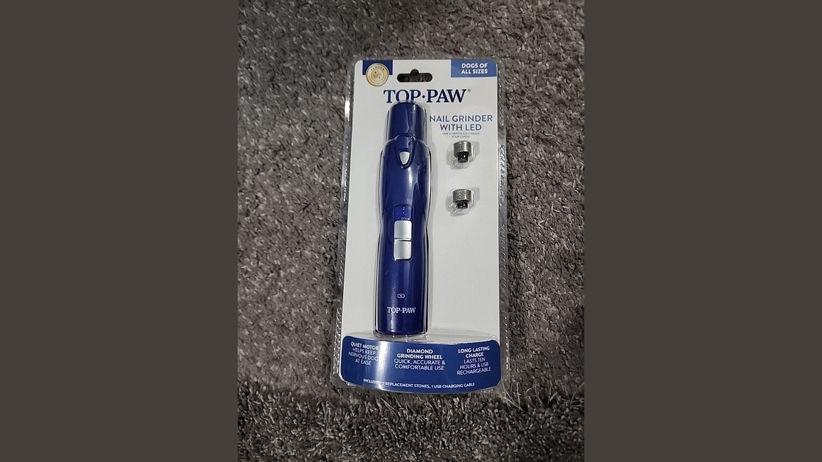Handheld toenail grinder with LED light on a towel on a bathroom counter