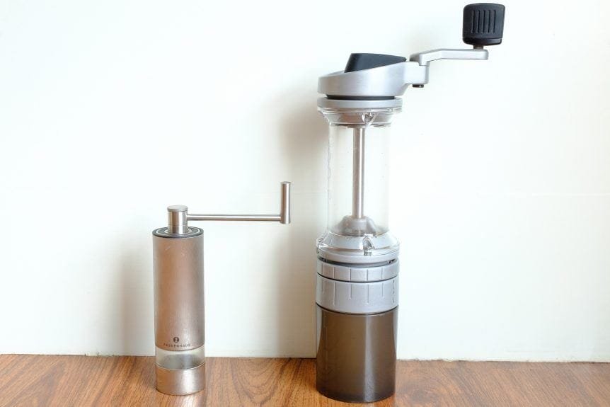 A high-quality manual coffee grinder rests on a marble counter for brewing perfect espresso.